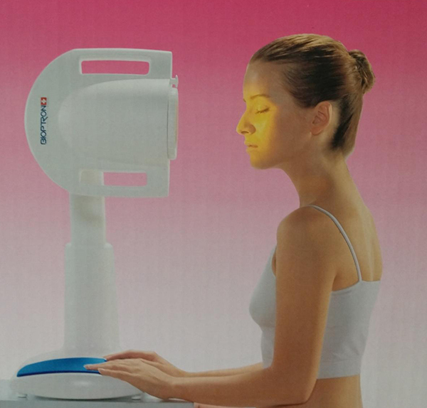 young woman using Bioptron Light Therapy machine