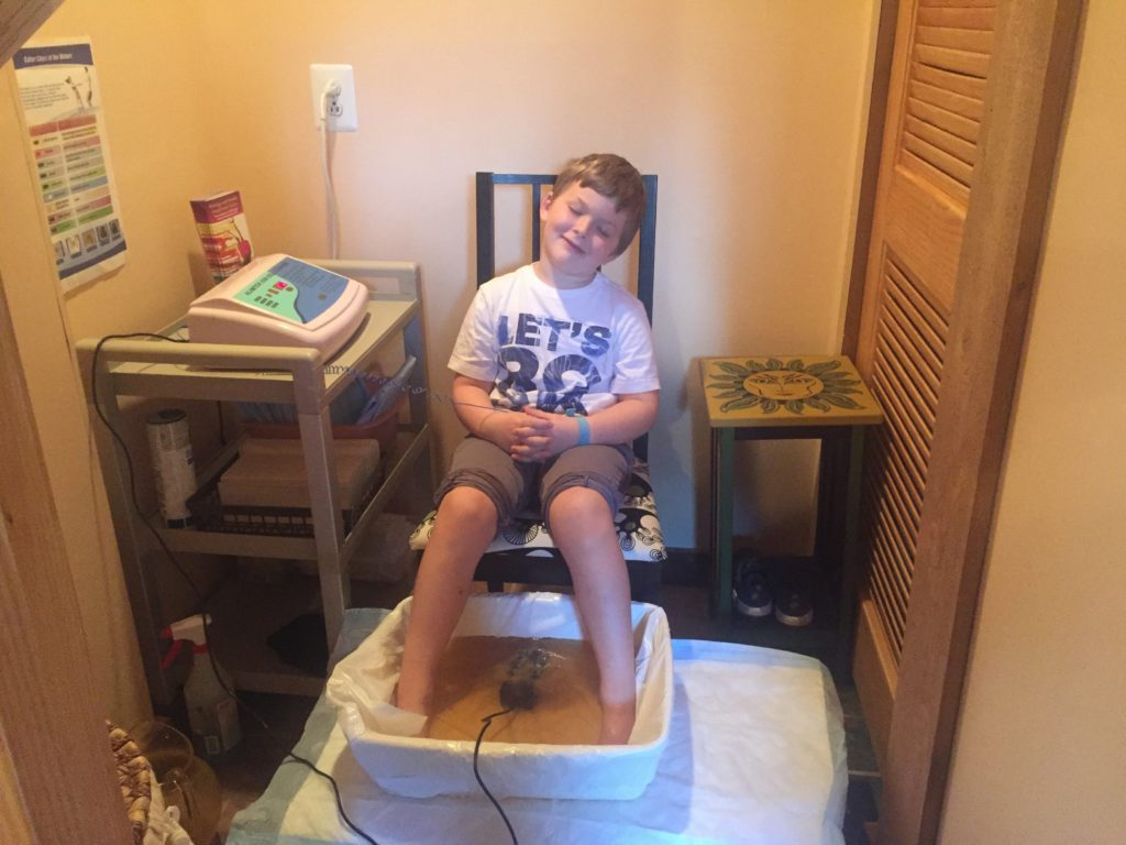 young boy receiving an Ion Cleanse foot bath treatment at Allergy & Health Solutions Center in Medford, NJ